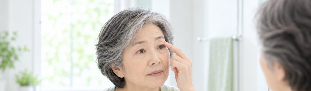 鏡の前でまぶたを気にする女性（イメージ）