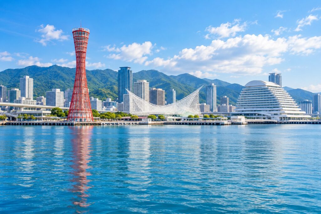 青空の下の神戸港と六甲山の街並み